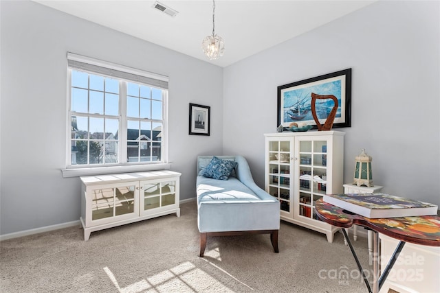 living area featuring baseboards, carpet, visible vents, and a notable chandelier