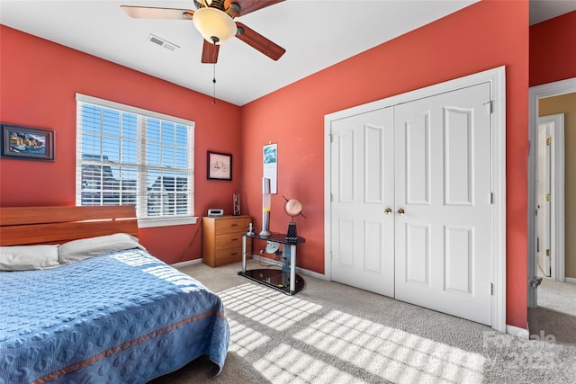 bedroom with a closet, visible vents, light carpet, and baseboards