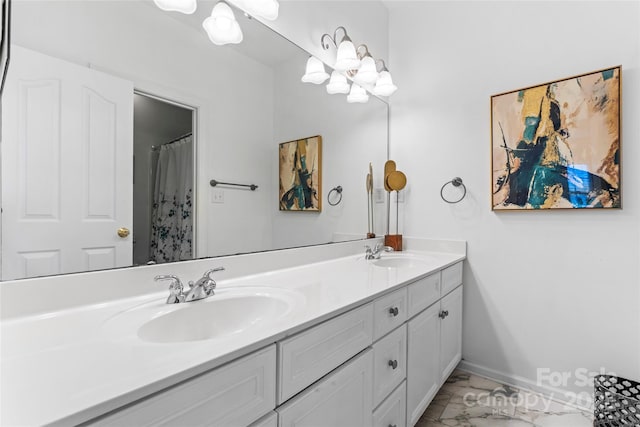 bathroom with marble finish floor, a sink, baseboards, and double vanity