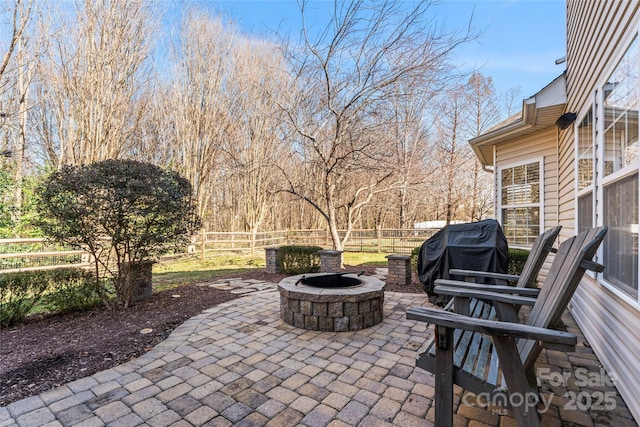 view of patio with an outdoor fire pit, a grill, and a fenced backyard