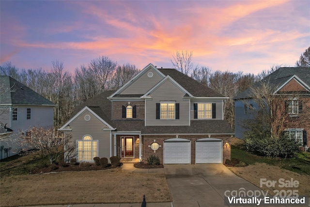 traditional home with a garage, concrete driveway, brick siding, and a front yard