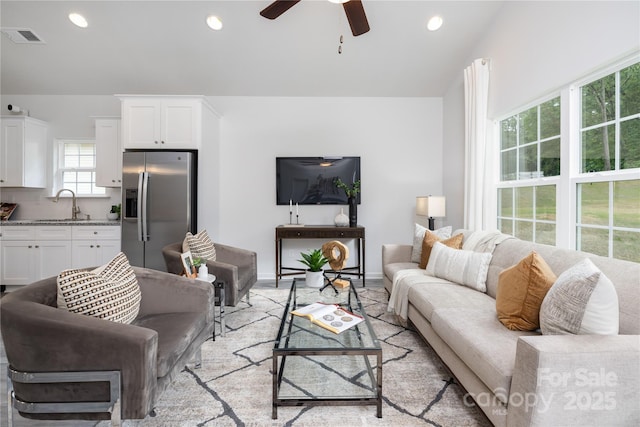 living room featuring a ceiling fan, recessed lighting, visible vents, and baseboards