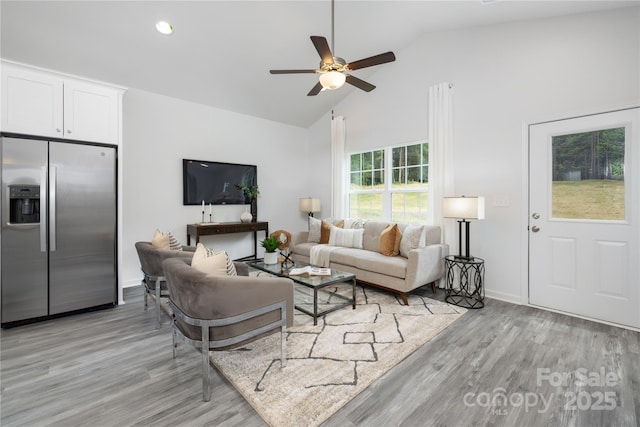 living area featuring baseboards, a ceiling fan, light wood-style flooring, high vaulted ceiling, and recessed lighting