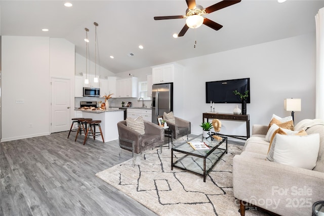 living room featuring light wood finished floors, recessed lighting, visible vents, ceiling fan, and high vaulted ceiling