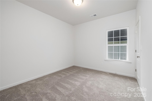 carpeted spare room featuring visible vents and baseboards