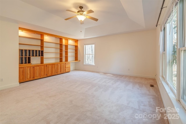 unfurnished room with light carpet, baseboards, and a tray ceiling