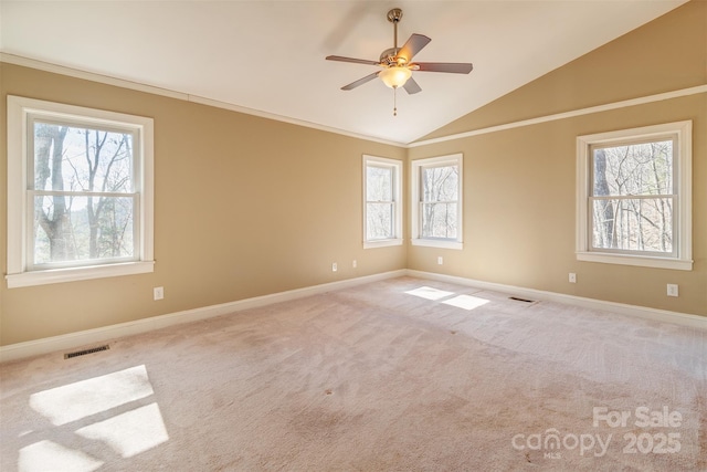 unfurnished room featuring lofted ceiling, visible vents, baseboards, carpet, and crown molding