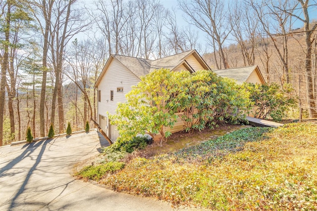 view of property exterior with driveway and an attached garage