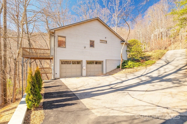 view of property exterior featuring a garage and driveway