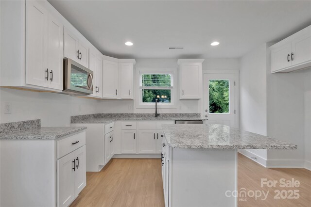 425 Messner St, Salisbury, NC 28144 - kitchen with stainless steel appliances, light wood finished floors, a center island, white cabinetry, and recessed lighting