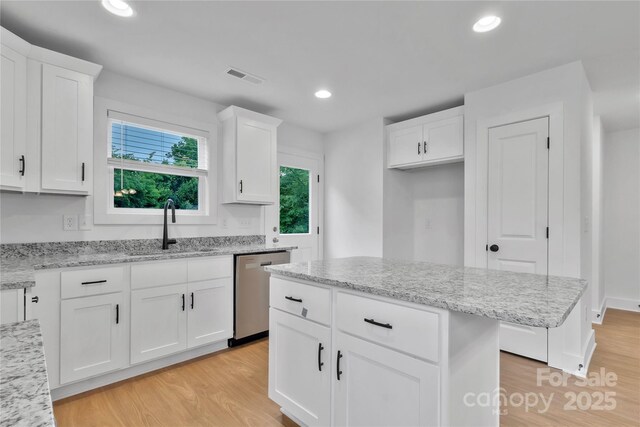 425 Messner St, Salisbury, NC 28144 - kitchen featuring dishwasher, light wood-style flooring, a sink, white cabinets, and light stone countertops