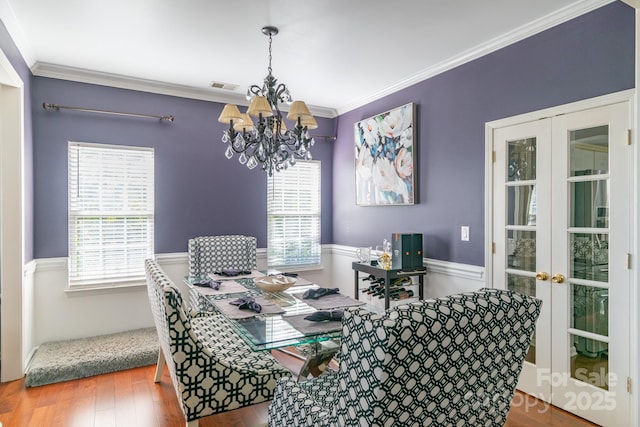 dining space featuring ornamental molding, french doors, visible vents, and wood finished floors