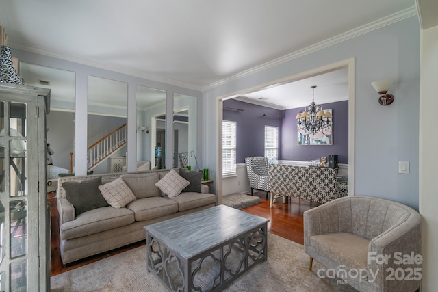 living room featuring stairs, crown molding, wood finished floors, and an inviting chandelier