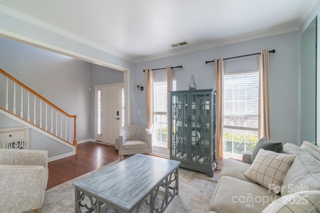 living room featuring stairway, plenty of natural light, visible vents, and wood finished floors