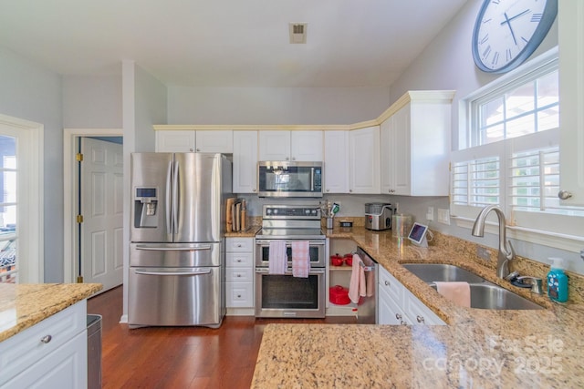 kitchen featuring appliances with stainless steel finishes, a sink, and white cabinets