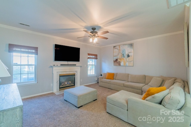 living area with carpet, a premium fireplace, visible vents, and crown molding