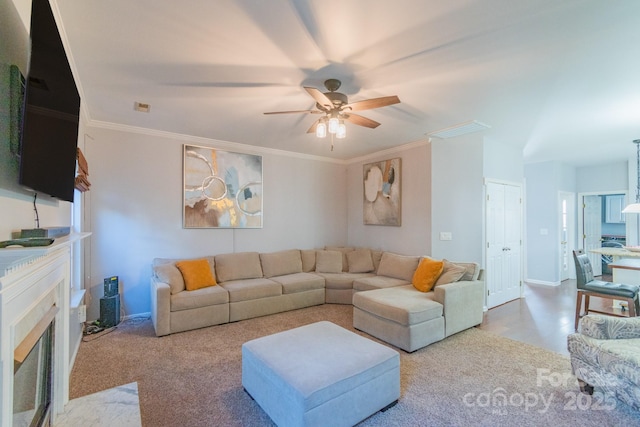 living room with visible vents, ornamental molding, a fireplace, and a ceiling fan