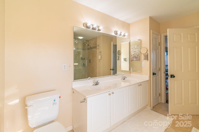 full bathroom featuring a stall shower, a sink, toilet, and double vanity