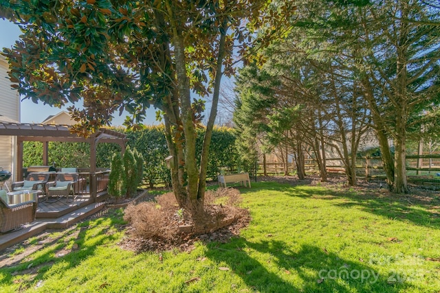 view of yard with fence, a wooden deck, and a pergola