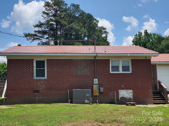 back of house featuring a yard, brick siding, crawl space, and central air condition unit