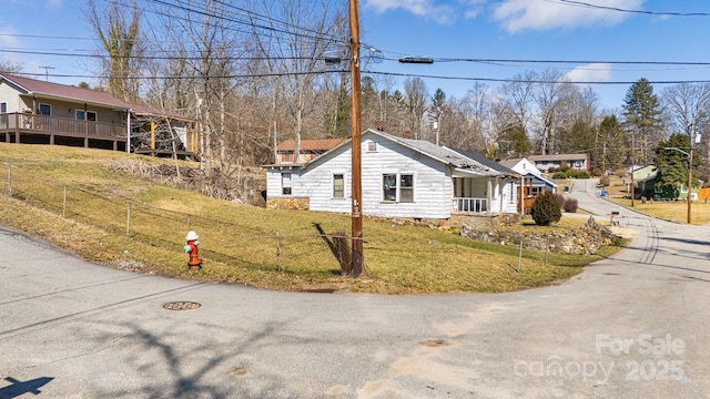 view of side of property featuring a lawn and fence