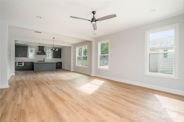 110 Walters St, Huntersville, NC 28078 - unfurnished living room featuring baseboards, light wood-type flooring, ceiling fan, and a sink