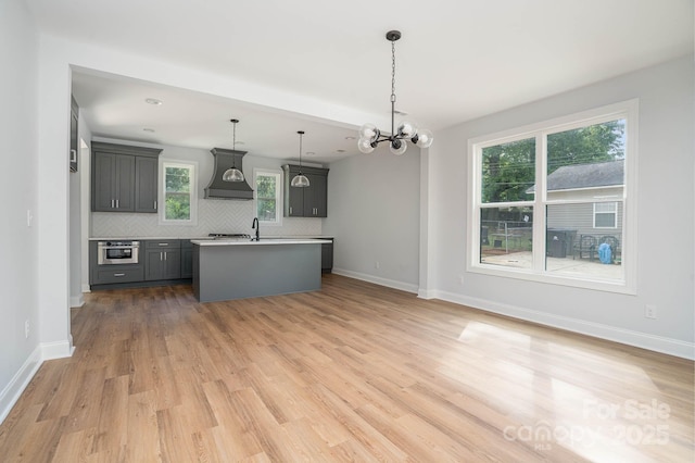 110 Walters St, Huntersville, NC 28078 - kitchen featuring premium range hood, decorative backsplash, an island with sink, stainless steel oven, and a chandelier