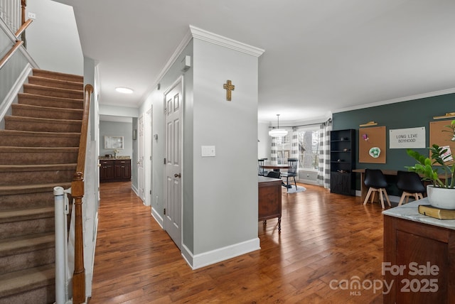 hallway with hardwood / wood-style flooring, baseboards, stairway, and ornamental molding