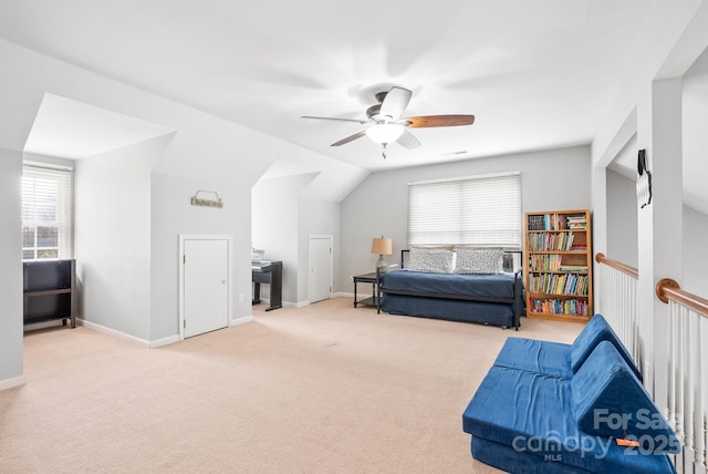 sitting room with ceiling fan, carpet, baseboards, and vaulted ceiling