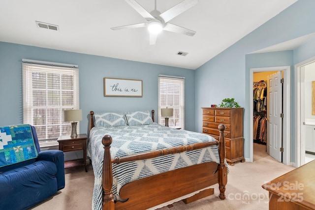 bedroom featuring a closet, visible vents, a spacious closet, light carpet, and multiple windows