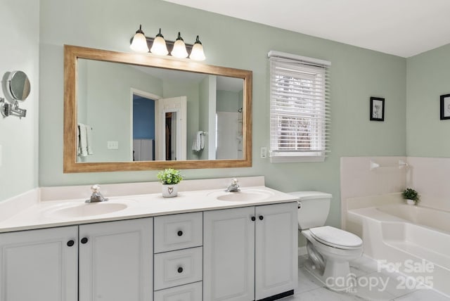 full bathroom with double vanity, a sink, toilet, and a bath