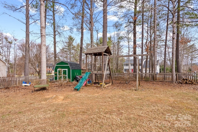 view of play area with a shed, fence, and an outbuilding