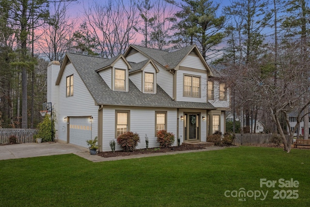 view of front facade featuring an attached garage, a shingled roof, fence, concrete driveway, and a front yard