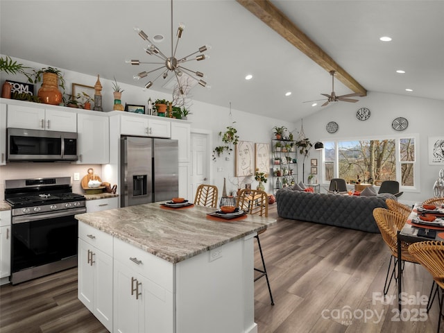 kitchen with stainless steel appliances, open floor plan, beamed ceiling, and dark wood-style flooring