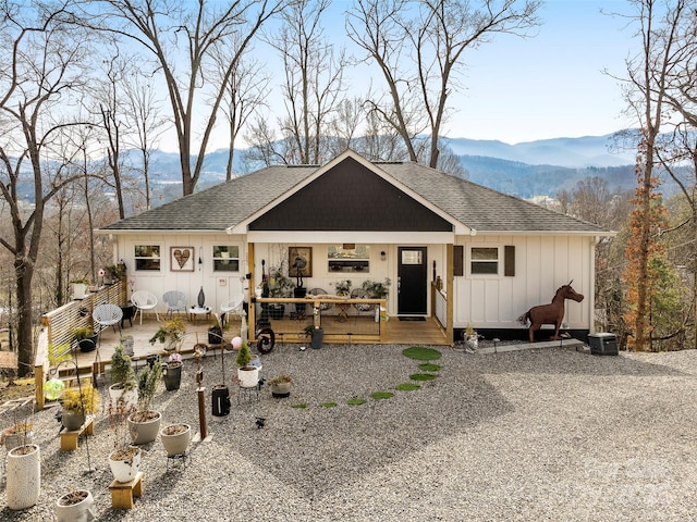 view of front of home featuring a mountain view, central AC, roof with shingles, board and batten siding, and a patio area