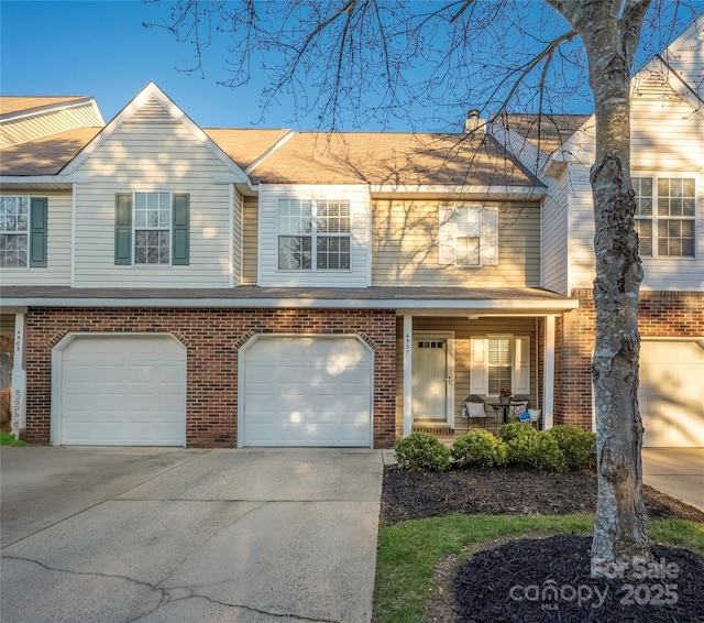 view of front of property with driveway, an attached garage, a porch, and brick siding