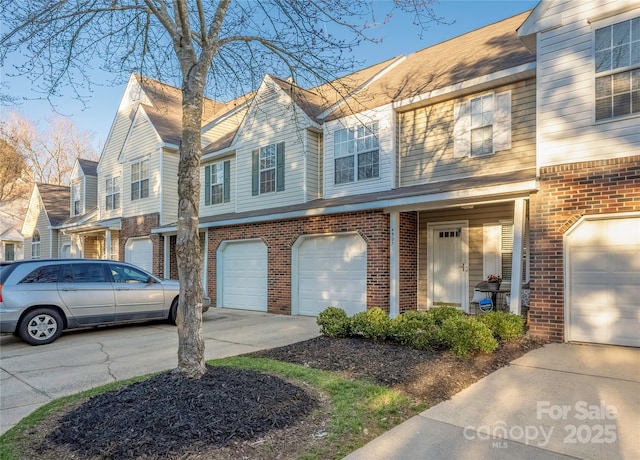 multi unit property featuring a residential view, brick siding, driveway, and an attached garage