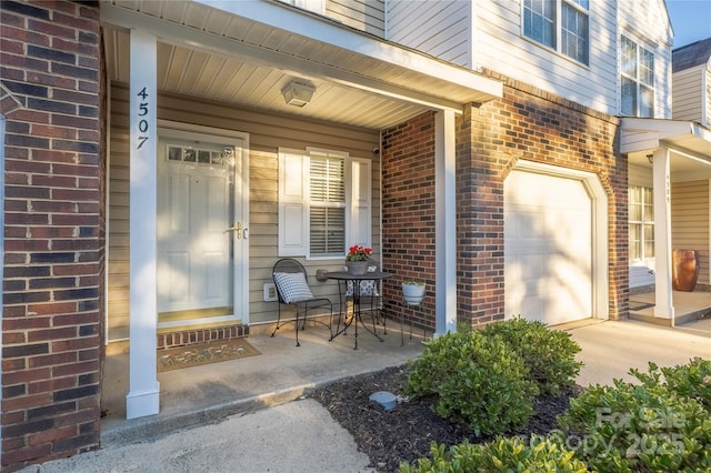 property entrance featuring a garage, brick siding, and a porch