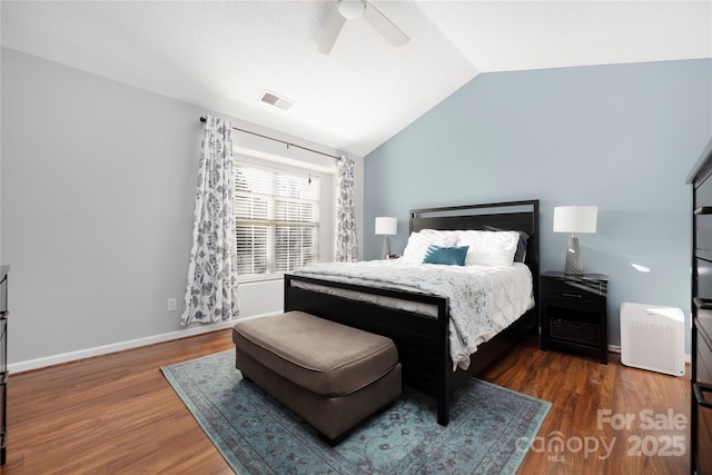 bedroom with visible vents, ceiling fan, vaulted ceiling, wood finished floors, and baseboards