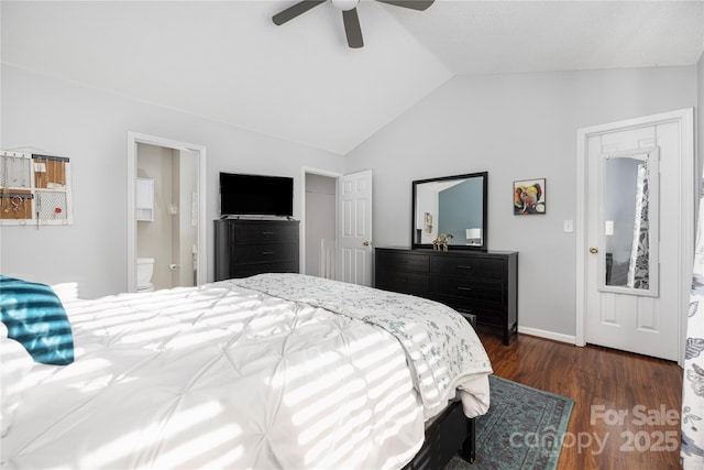 bedroom with baseboards, dark wood finished floors, a ceiling fan, ensuite bath, and vaulted ceiling