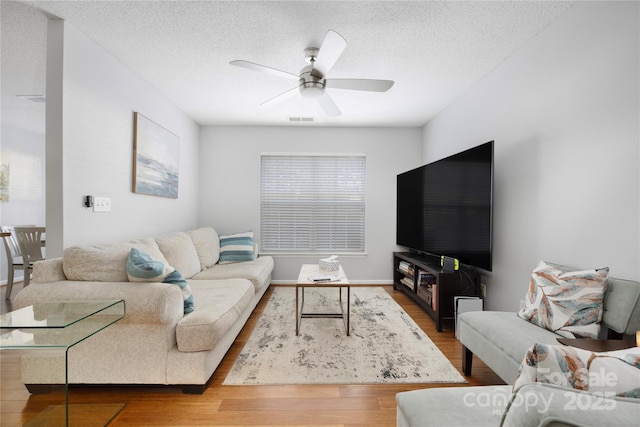 living room with visible vents, ceiling fan, a textured ceiling, and wood finished floors