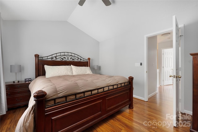 bedroom with a ceiling fan, vaulted ceiling, baseboards, and wood finished floors