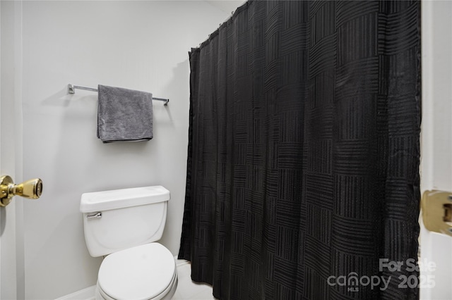 full bathroom with curtained shower and toilet