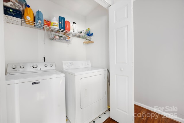 washroom with laundry area, separate washer and dryer, and baseboards