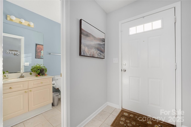 entryway with light tile patterned flooring and baseboards