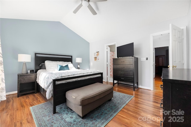 bedroom with a ceiling fan, baseboards, vaulted ceiling, and wood finished floors