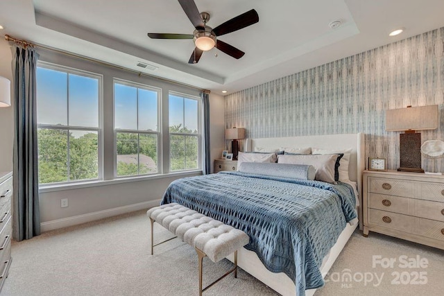 carpeted bedroom featuring visible vents, baseboards, a tray ceiling, recessed lighting, and wallpapered walls