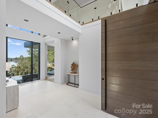 interior space featuring a high ceiling and baseboards