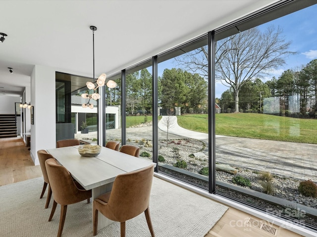 sunroom / solarium with a chandelier and visible vents