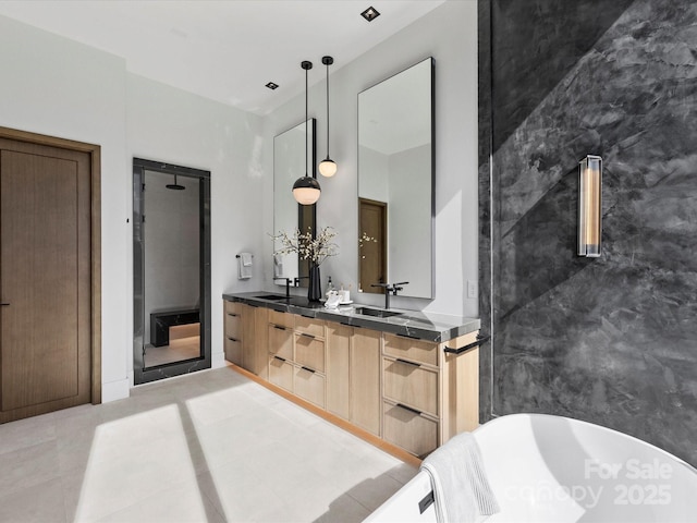 full bathroom featuring double vanity, tile patterned flooring, a freestanding bath, a shower stall, and a sink